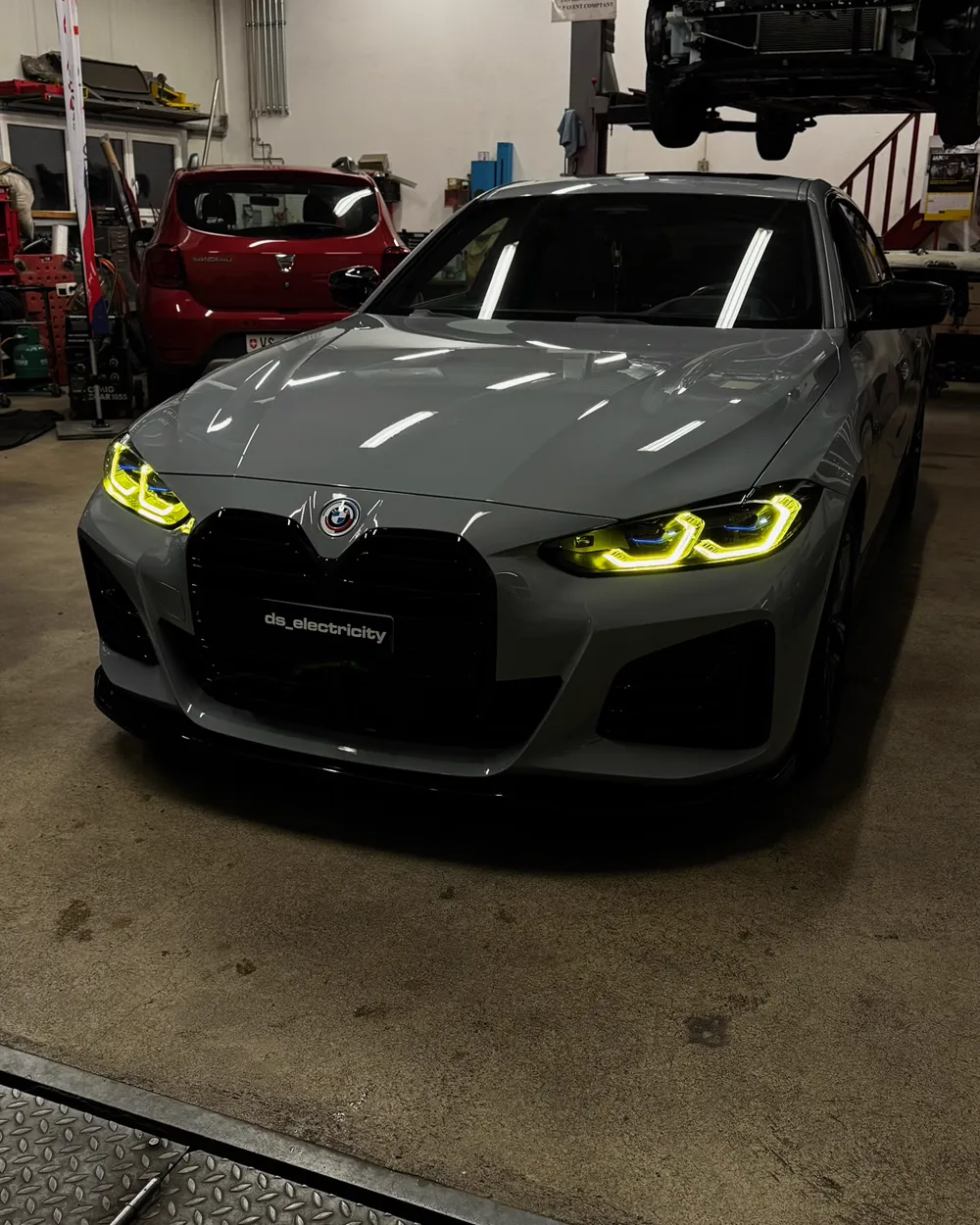 BMW M4 avec feux de jour jaunes dans l'atelier