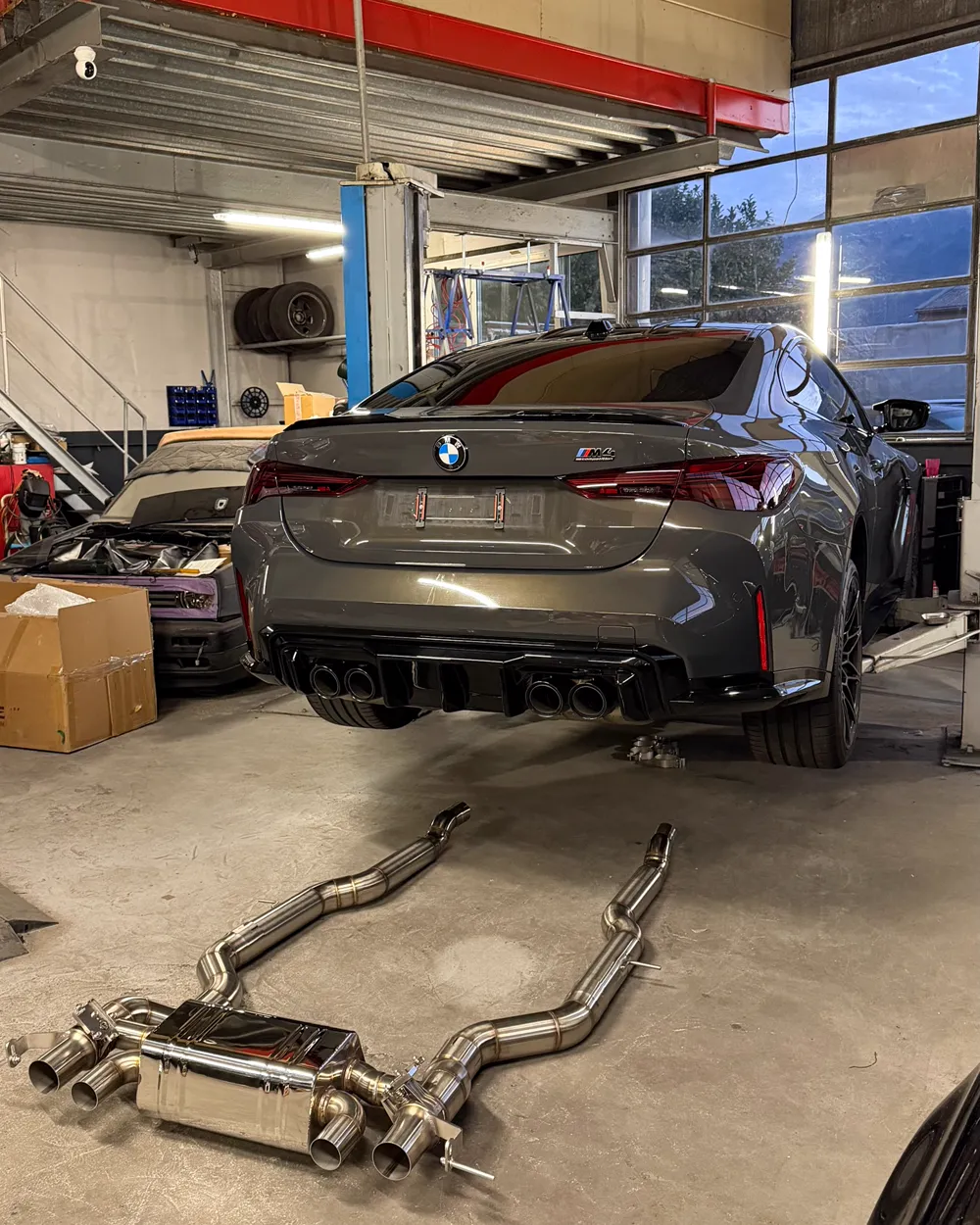 Ligne d'échappement déposée sous une BMW sur le pont